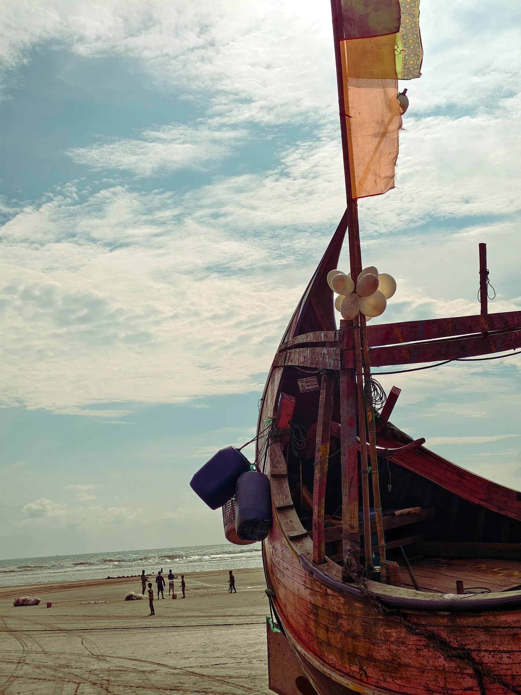 Close-up perspective of the curved wooden bow of a boat overlooking the ocean